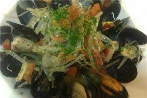 Mussels in a white wine butter sauce with leeks and tomatoes